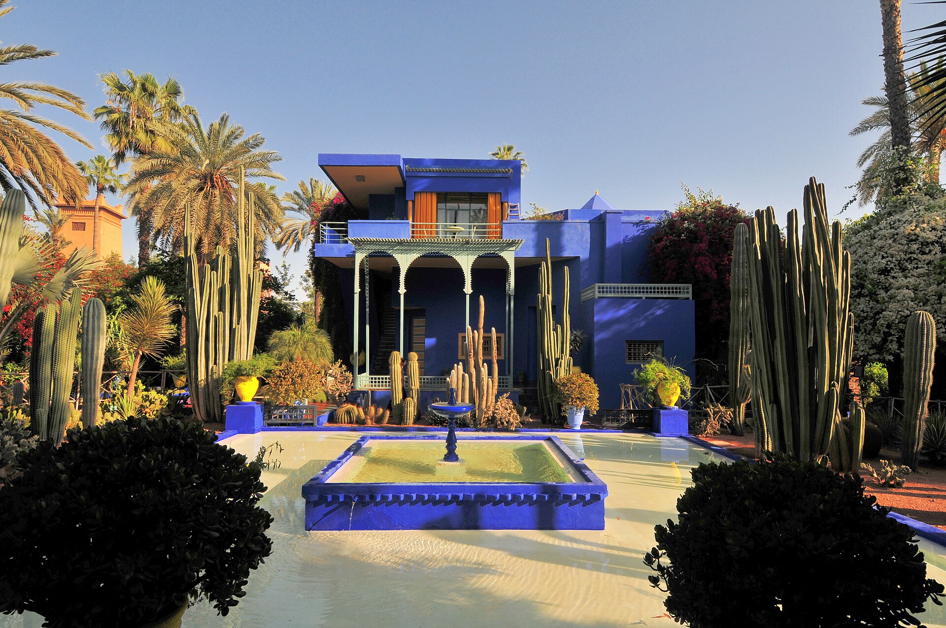 The cobalt-blue Majorelle villa framed by palms, cacti and a reflecting pool